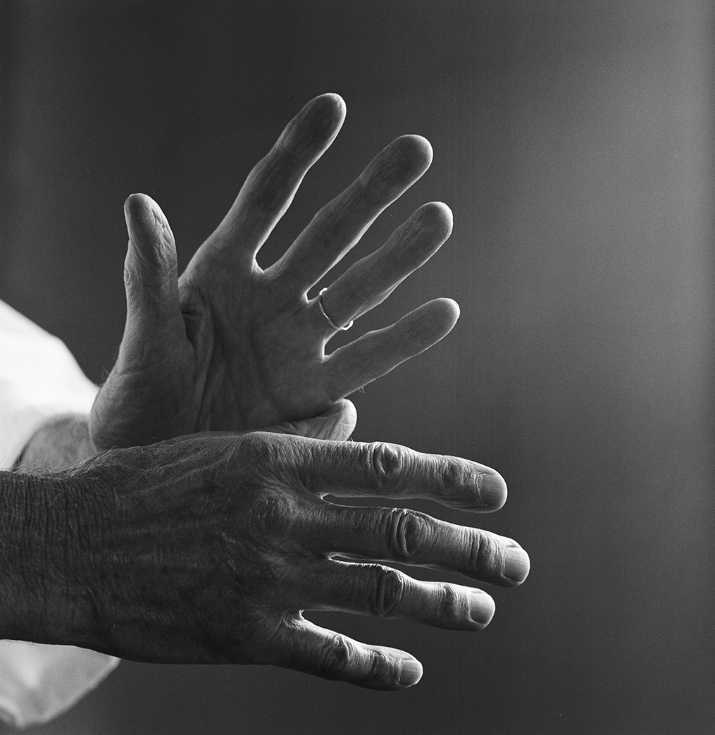 Black and white photograph of two hands staggered in a fan-like gesture.